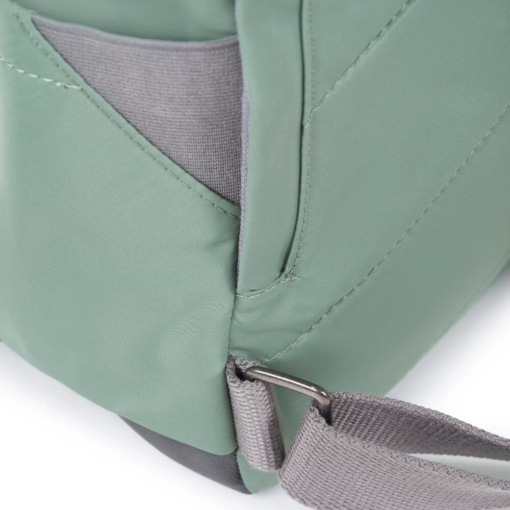 Close-up of a green and gray bag with a strap on a white background
