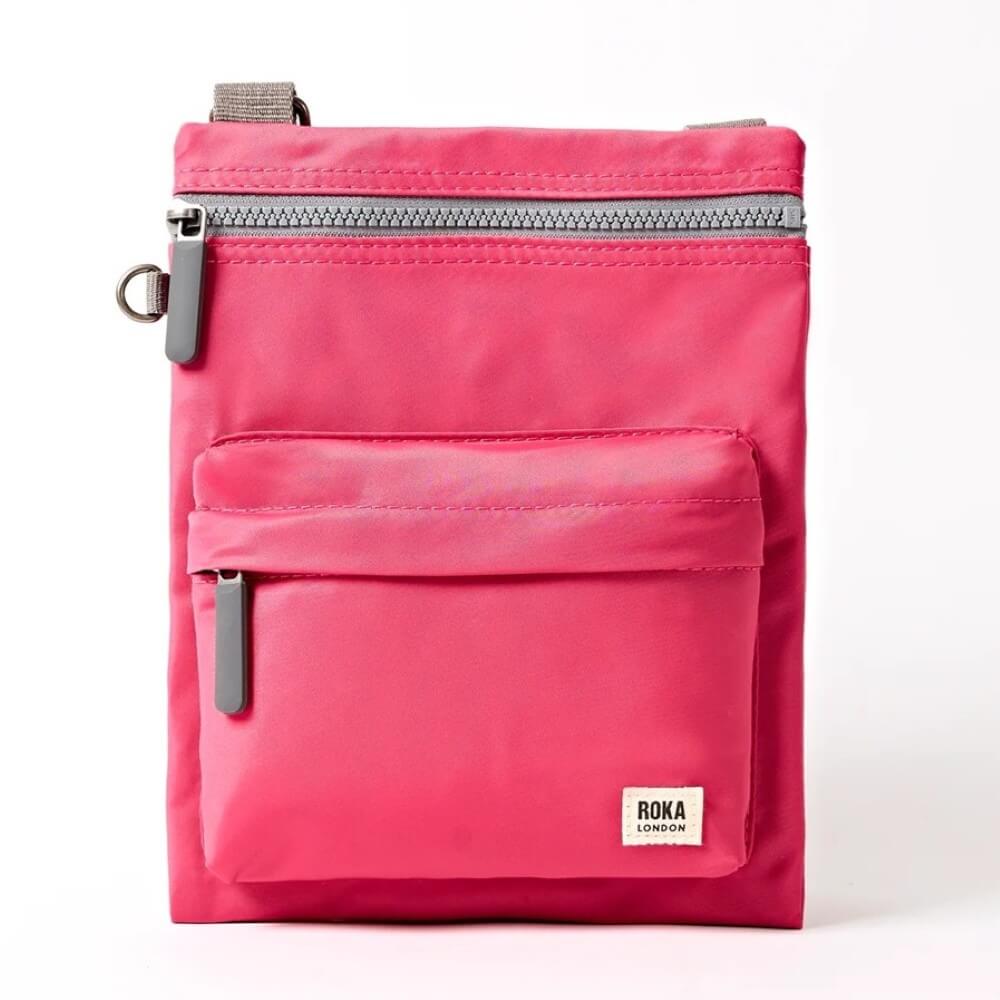 Pink Roka crossbody bag with a visible brand label on a white background