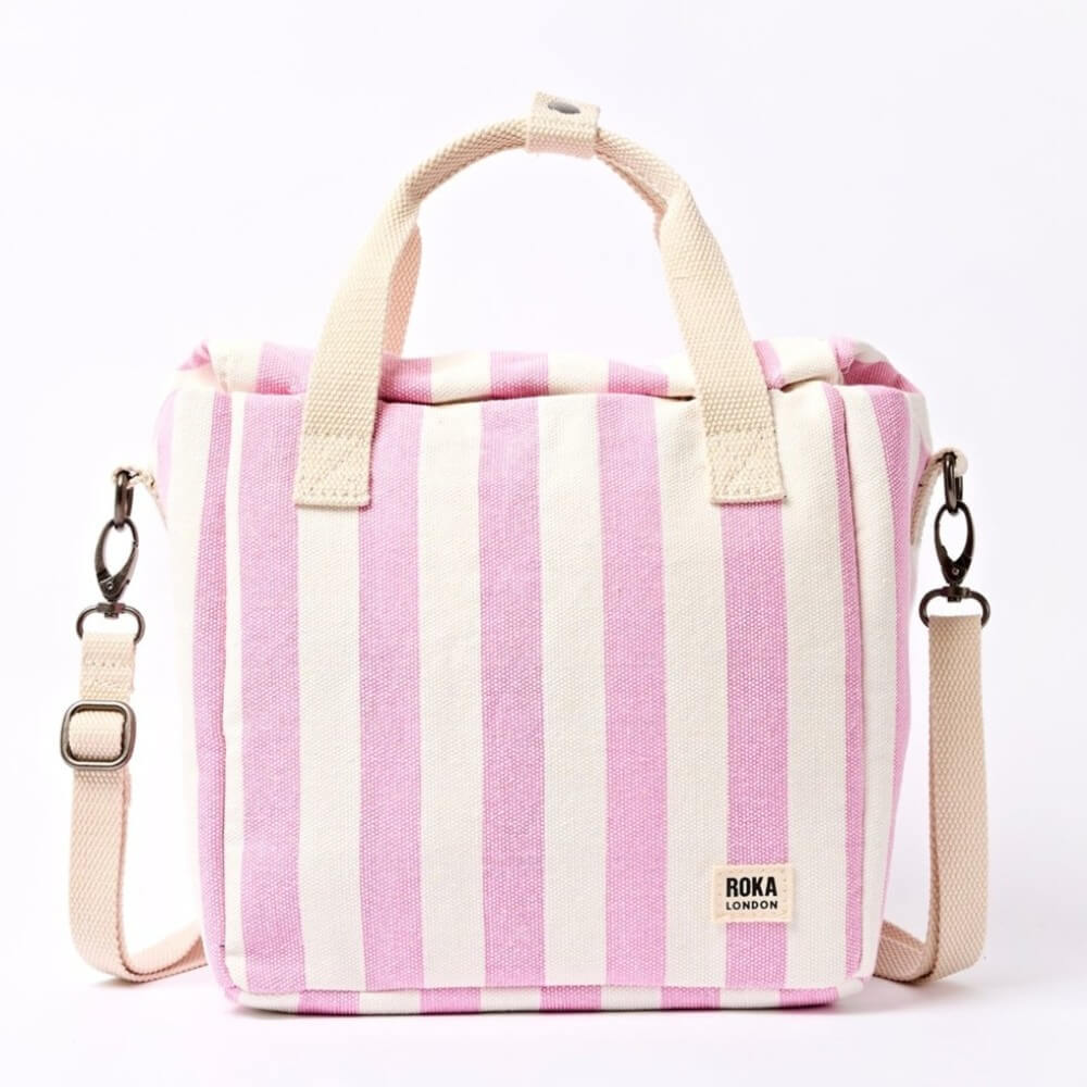 Roka Pink and white striped insulated lunch bag with a shoulder strap on a white background