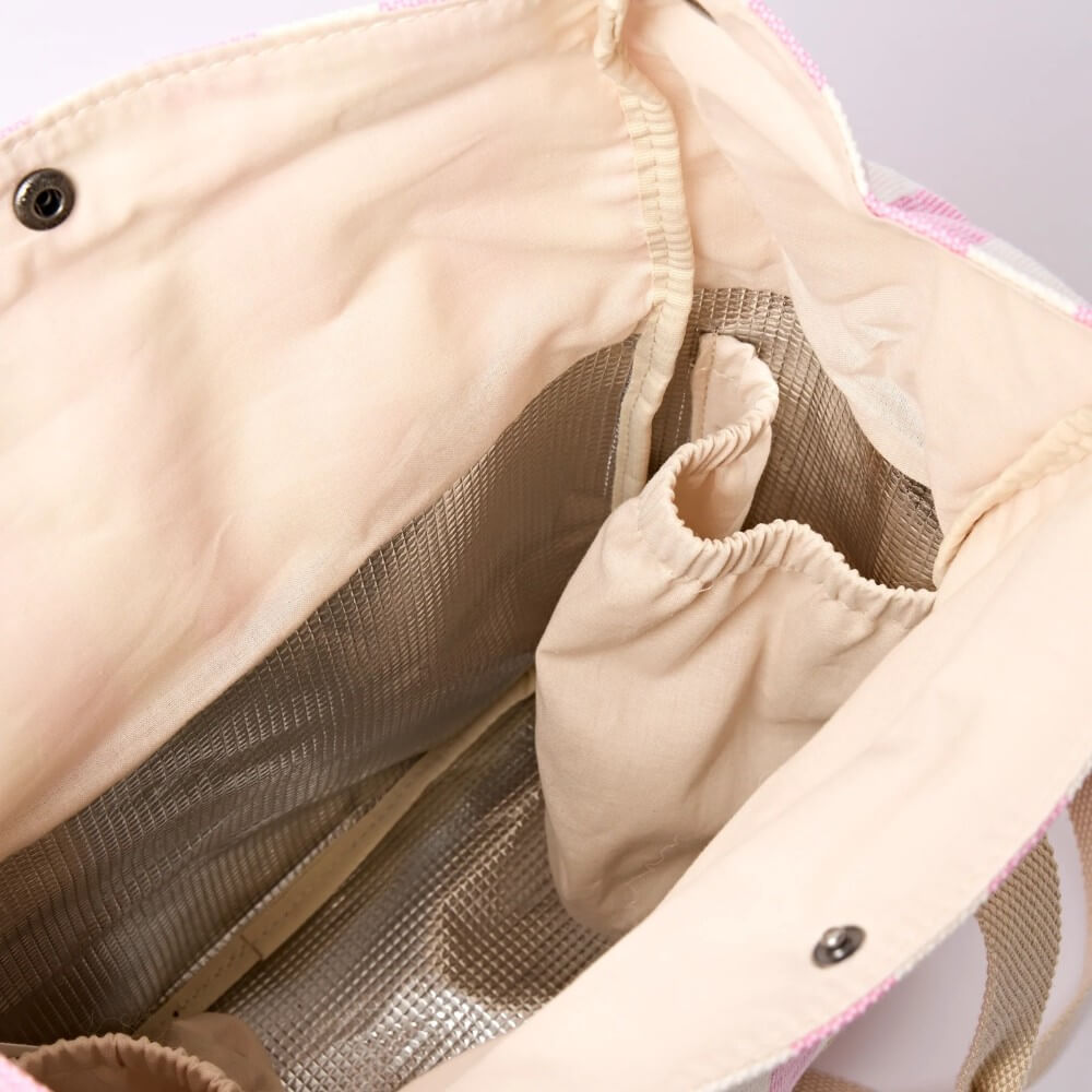 inside look at a Roka Pink and white striped insulated lunch bag with a shoulder strap on a white background