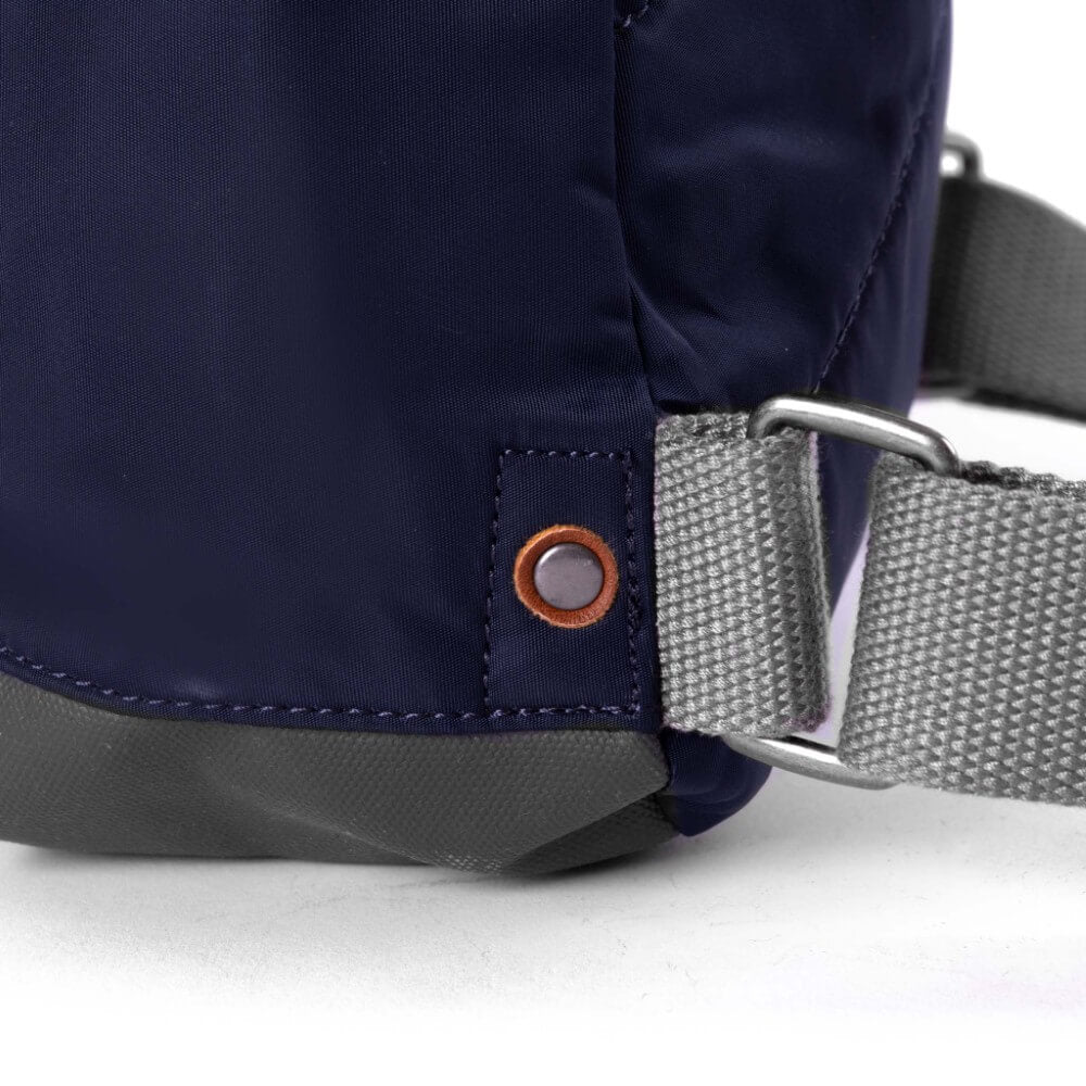 Navy blue bag with a gray strap and metal buckle on a white background