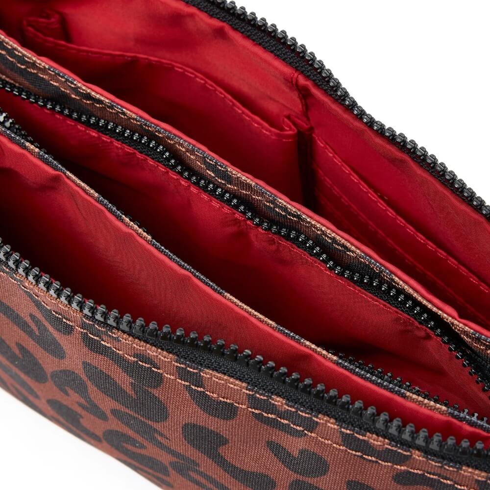 Close-up of a red interior with leopard print exterior of a bag.