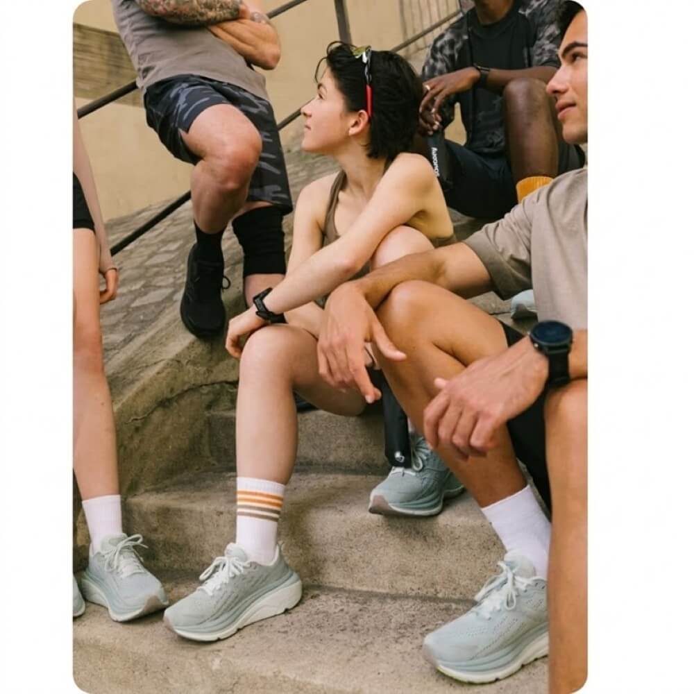 People sitting on steps with a focus on their Saucony shoes and clothing.