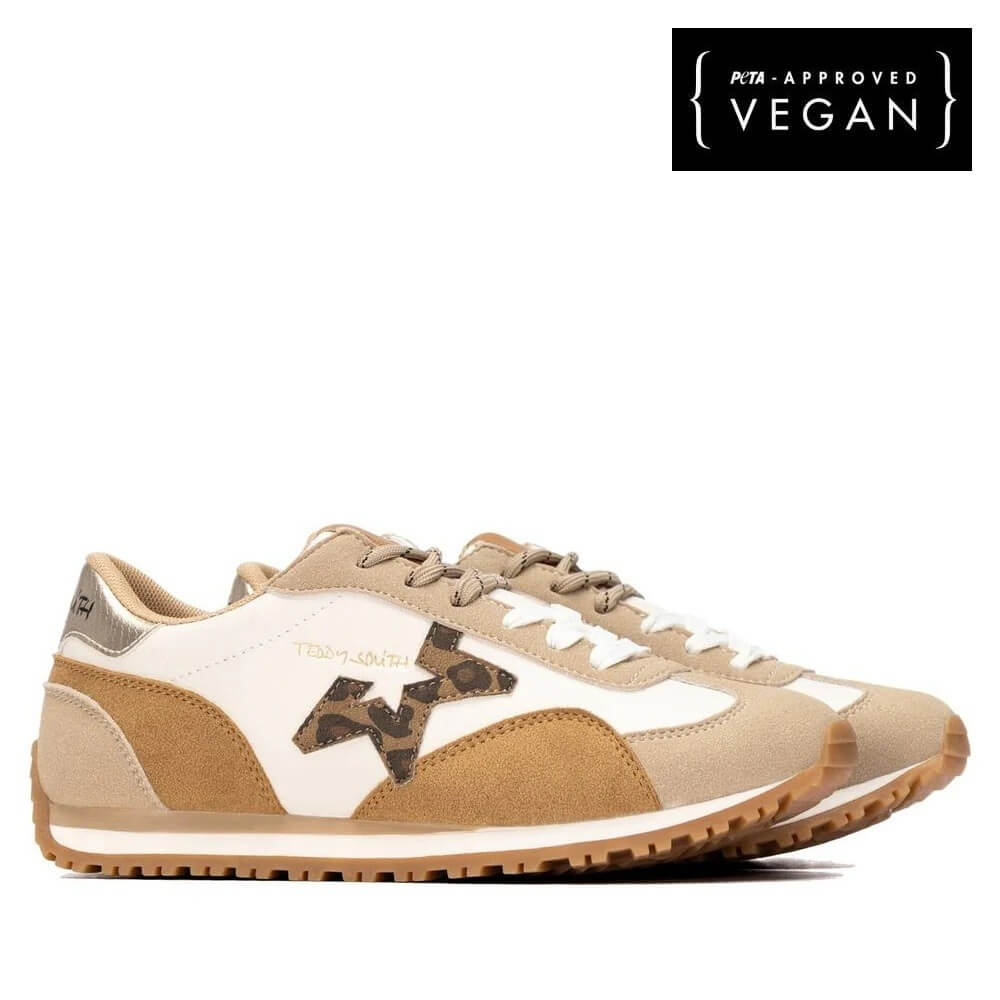A pair of Teddy Smith low-top sneakers in beige, white, and brown suede with a leopard-print patterned logo, shown from a side profile on a white background with a black 'Vegan Approved' badge in the top right.