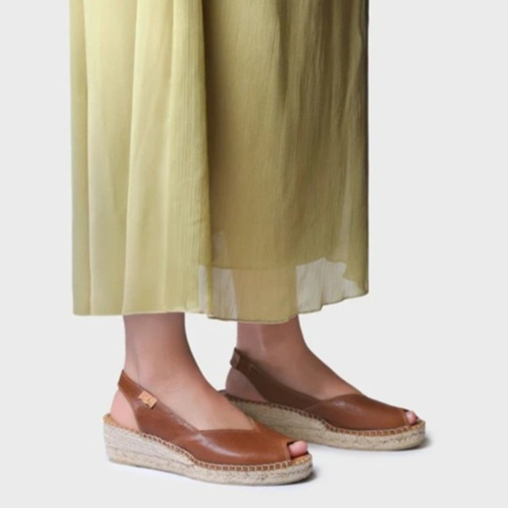 Toni Pons Brown sandals worn with light green pants on a plain background