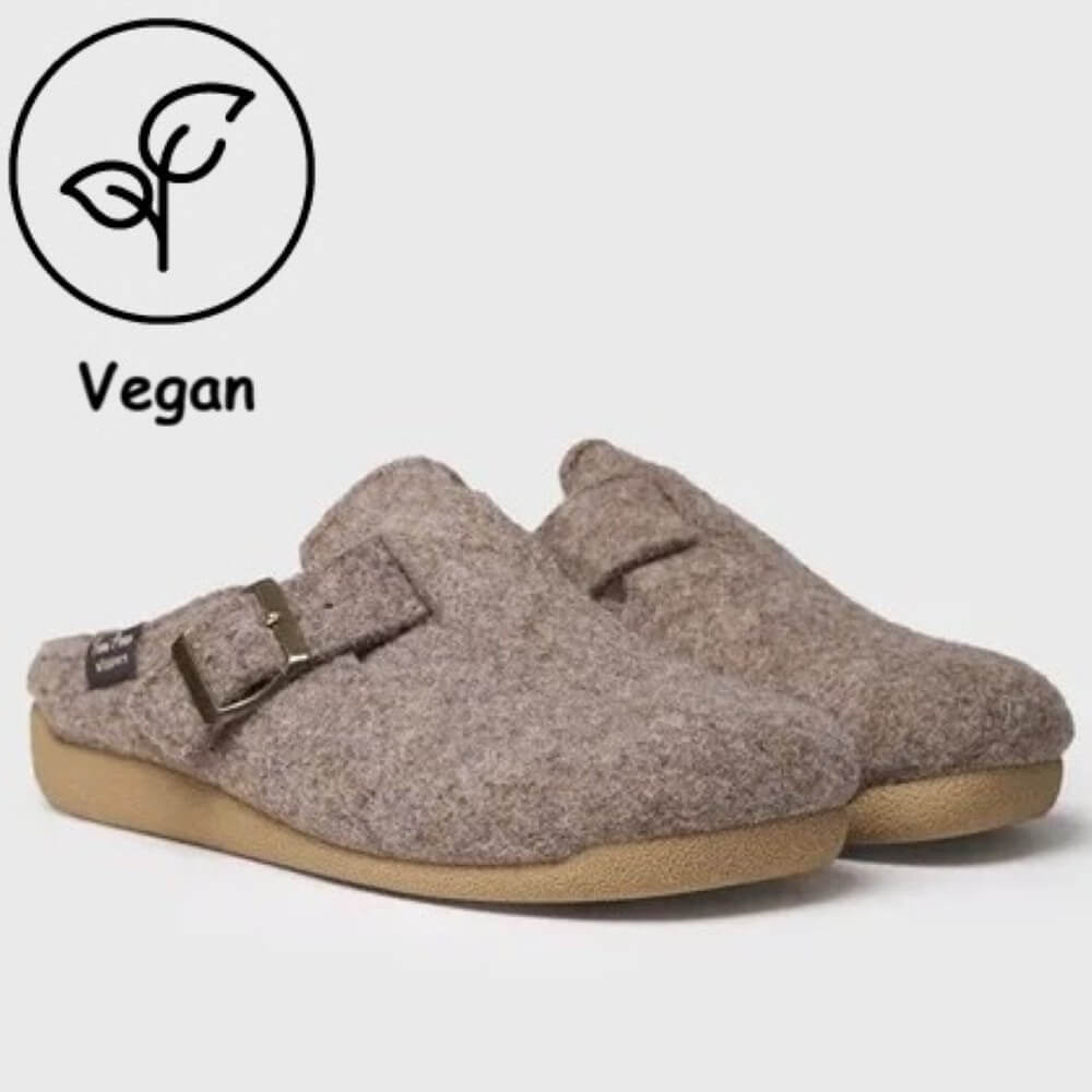 A pair of brown felt clogs with tan soles and metal buckles, shown on a light gray background with a 'Vegan' leaf icon overlay in the top-left corner.