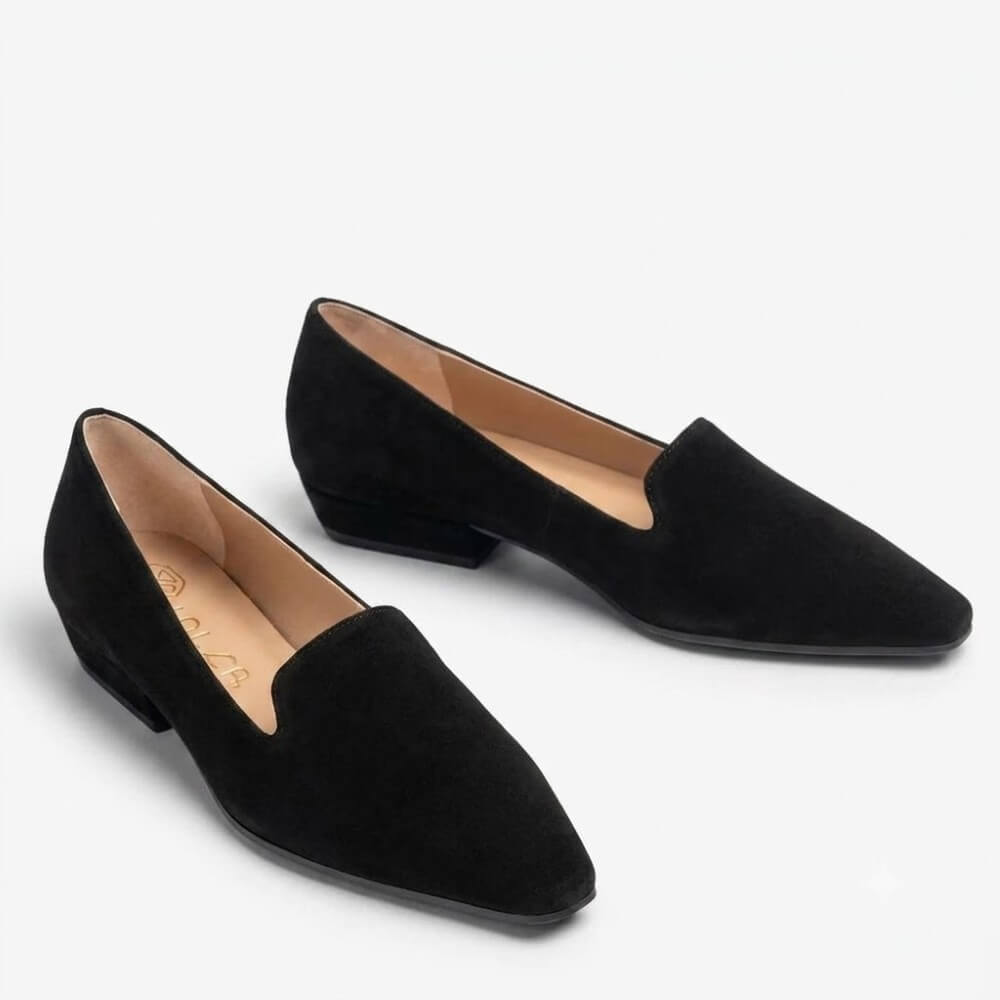 A pair of Unisa black suede pointed-toe flats with low block heels, displayed on a clean white background.