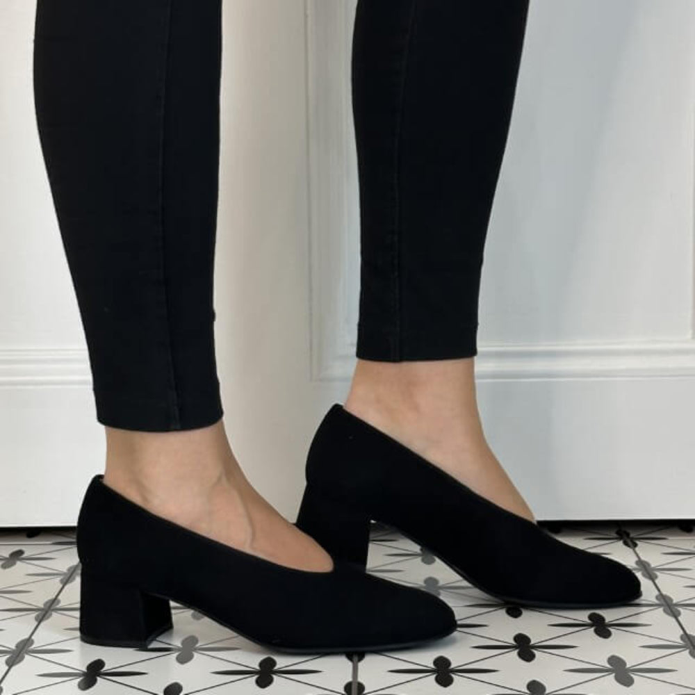 Unisa Black Suede Block heel court shoe worn with black pants on a tiled floor