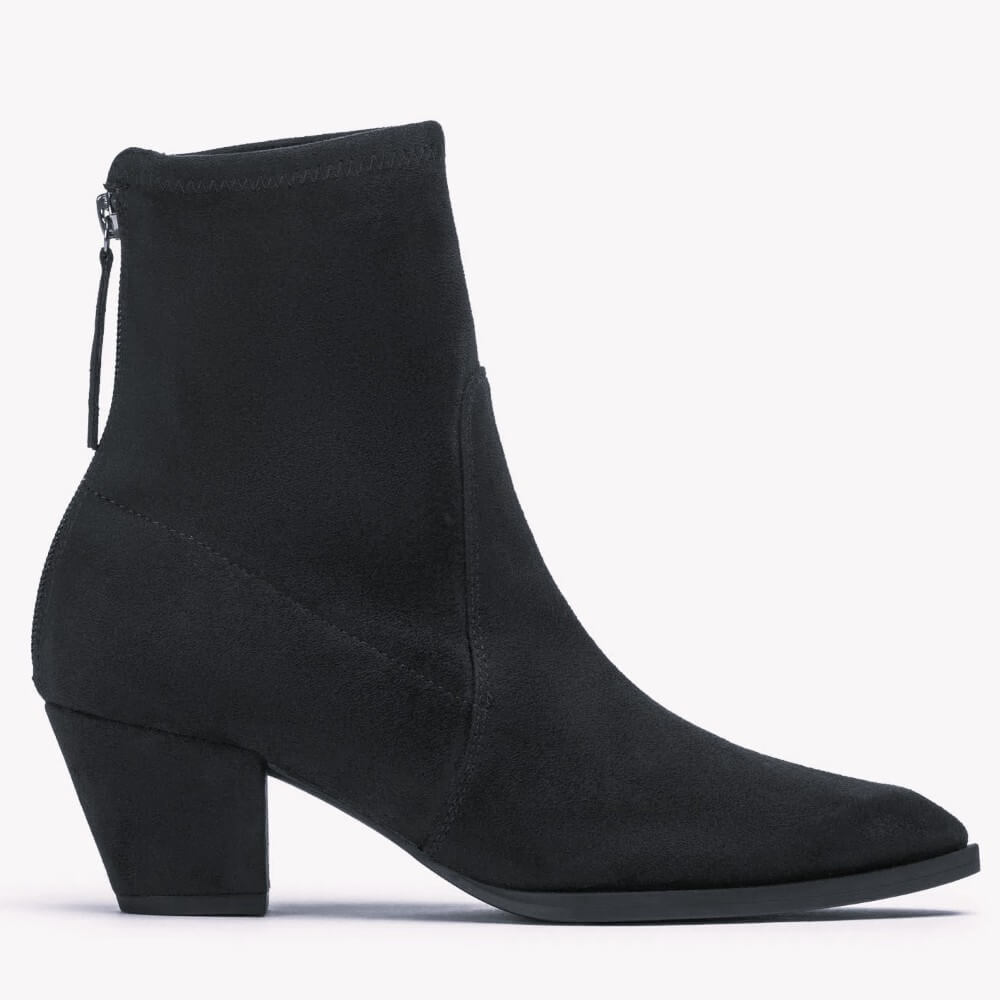 A Unisa black suede ankle boot with a block heel, pointed toe, and a back zipper, shown in profile against a white background.