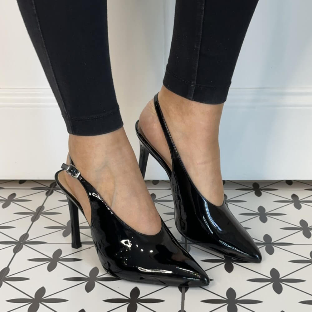 Black patent high-heeled shoes worn with black leggings. Unisa Tabar Patent Leather Slingback