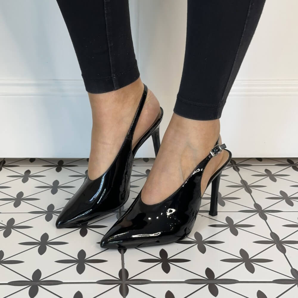 Black patent high-heeled shoes worn with black leggings. Unisa Tabar Patent Leather Slingback