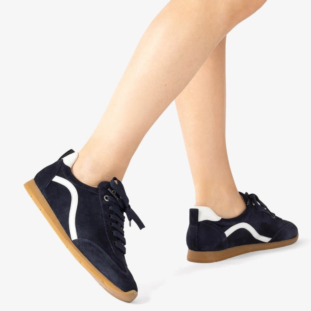 Navy blue sneakers with white soles worn by a person on a white background Unisa Dalai Suede Trainer Navy