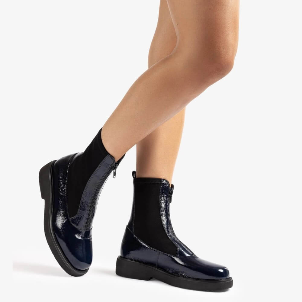 Navy patent leather boots worn by a person on a white background Unisa Foggia Centre Zip Patent Leather Boot Navy