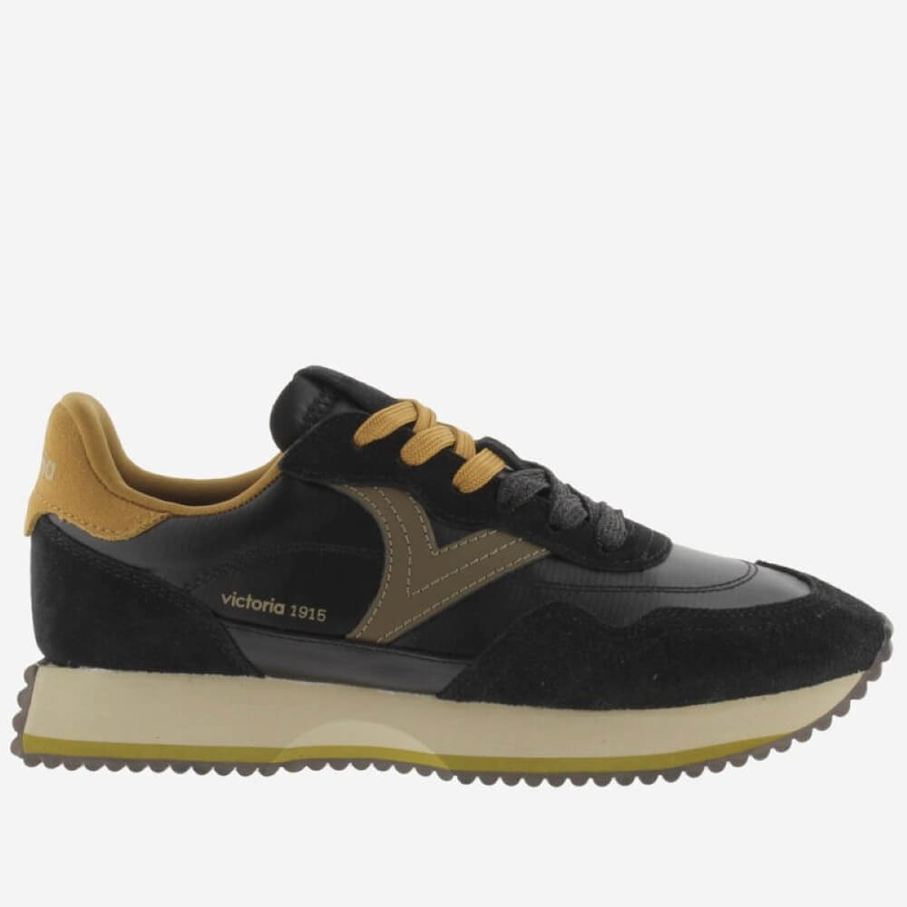 A black and brown suede and leather low-top sneaker by Victoria 1915, featuring mustard yellow laces, a tan heel tab, and a thick beige midsole with a yellow-gold outsole.