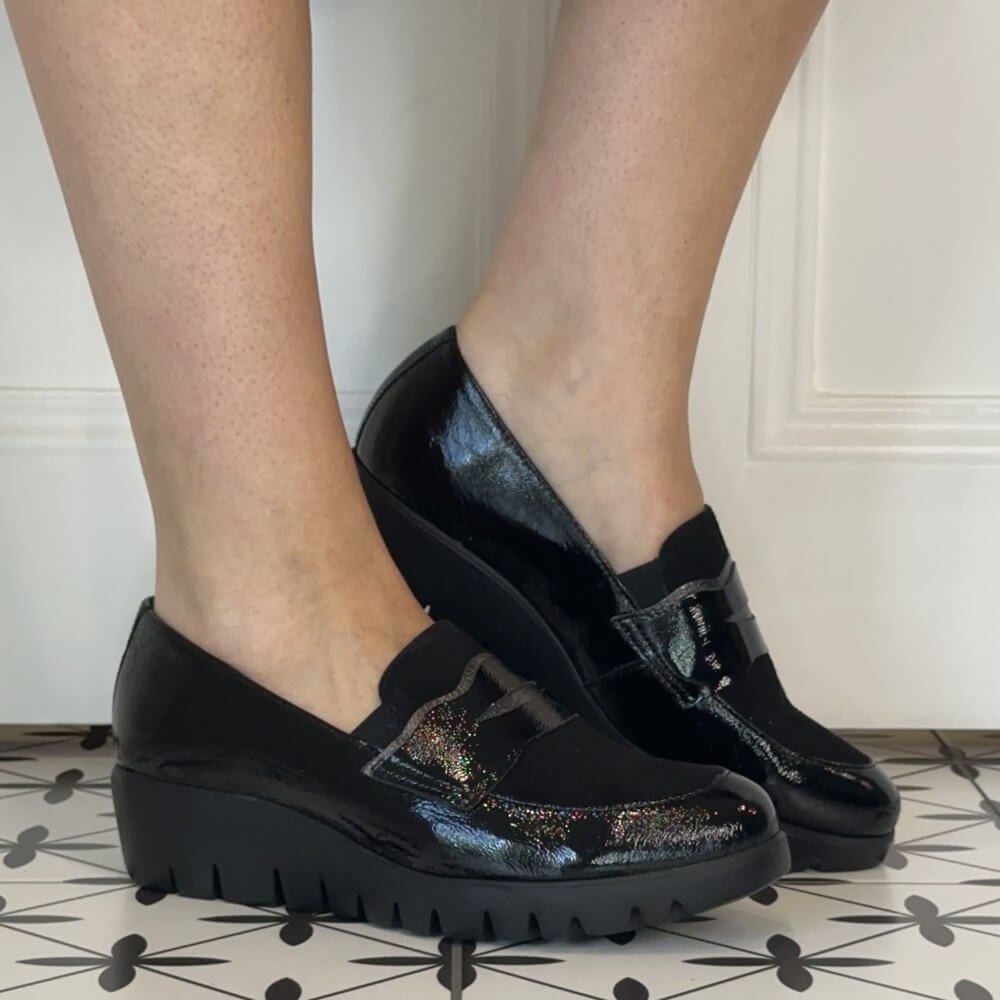 Person wearing Wonders Patent and suede leather wedge loafers on a tiled floor
