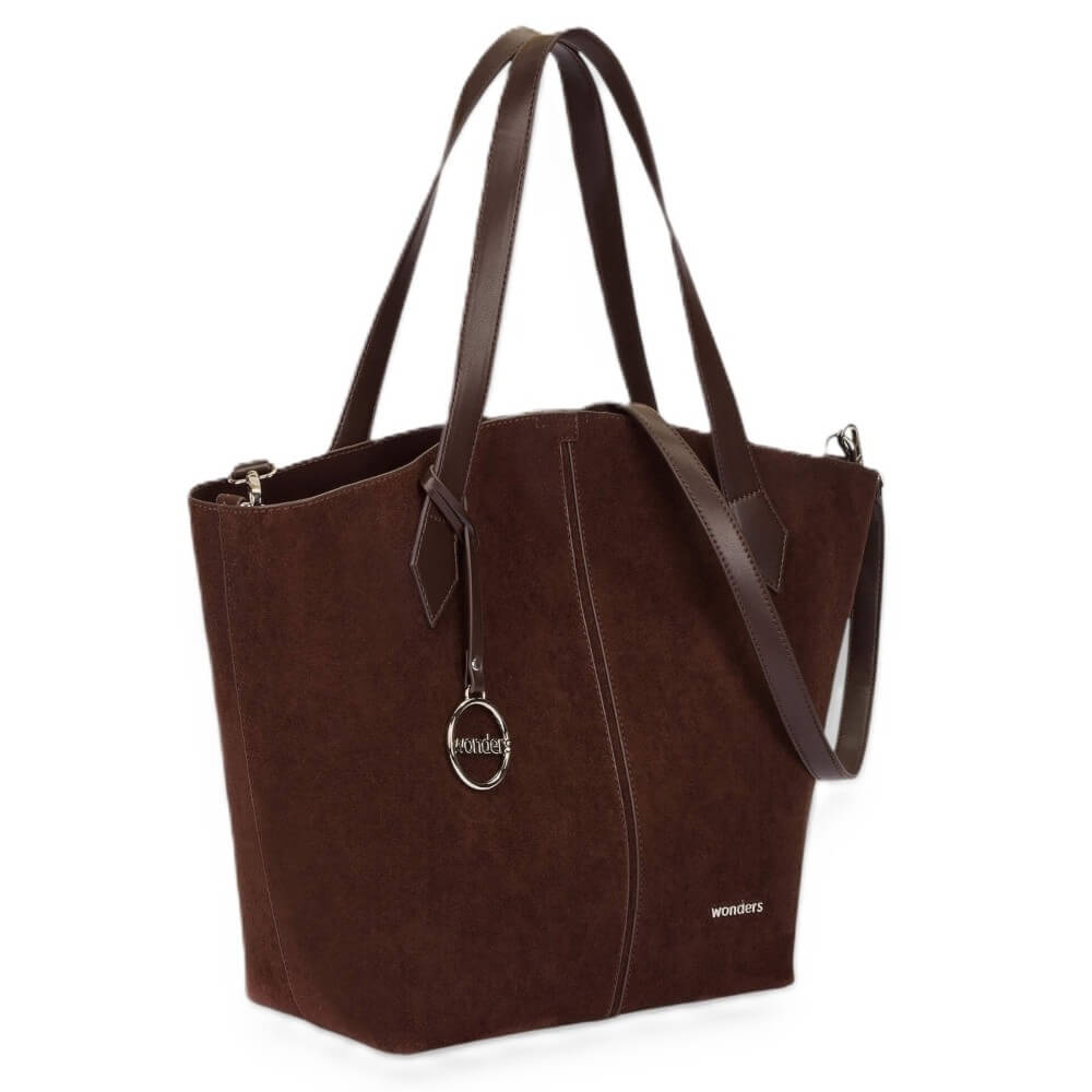 A dark brown suede tote bag with dark brown leather handles and a silver-tone hanging logo charm, shown on a plain white background.