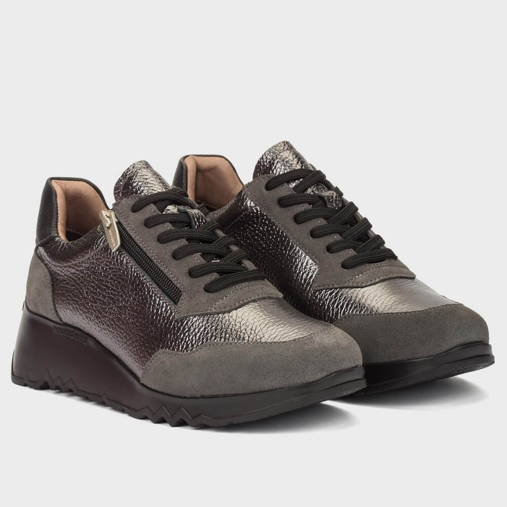 A pair of Wonders low-top sneakers in a mix of dark brown, grey, and metallic silver textures, featuring black laces and a chunky black sole, shown against a light grey background.