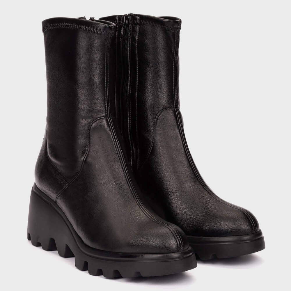 A pair of Wonders black leather ankle boots with chunky lug soles, shown from a side profile view against a light grey background.