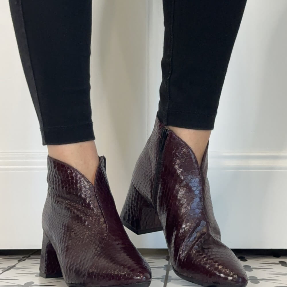 Wonders women's snakeskin-textured ankle boots in a deep burgundy colour, shown on a model wearing black skinny jeans.