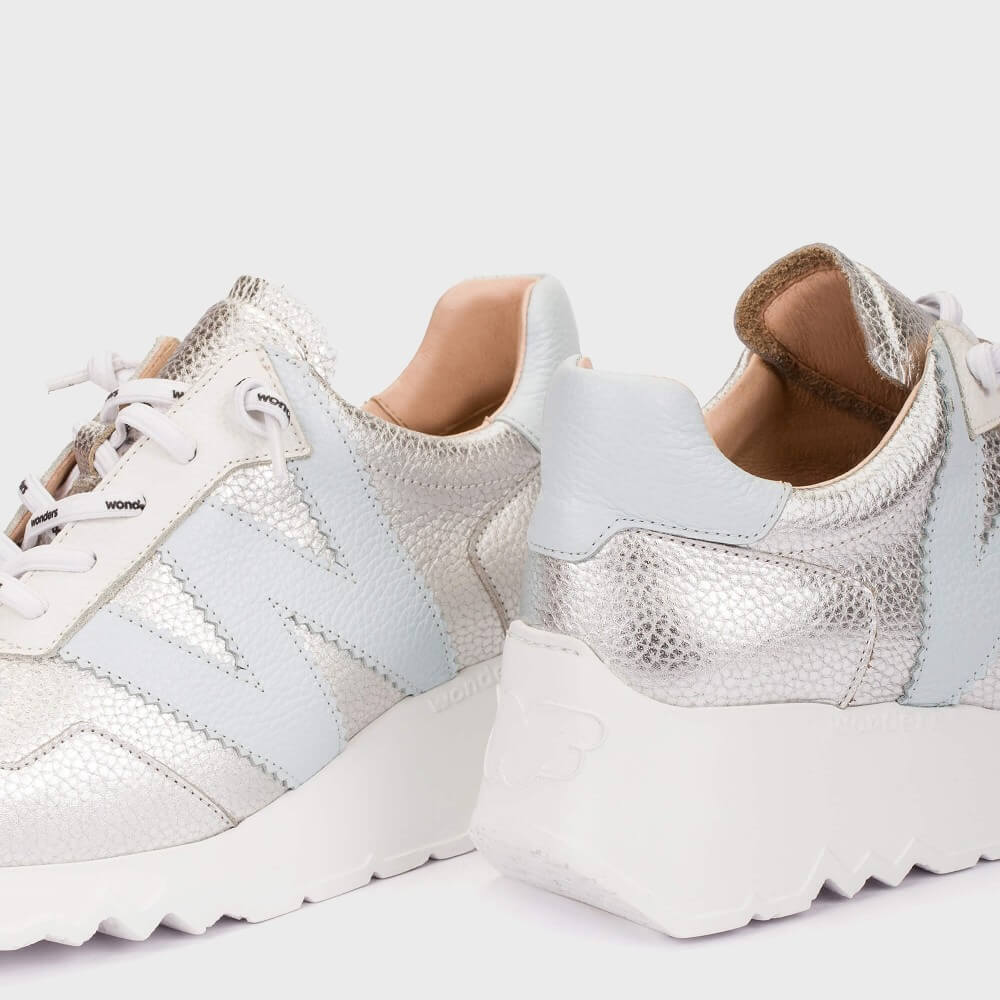 White sneakers with snake skin pattern on a white background