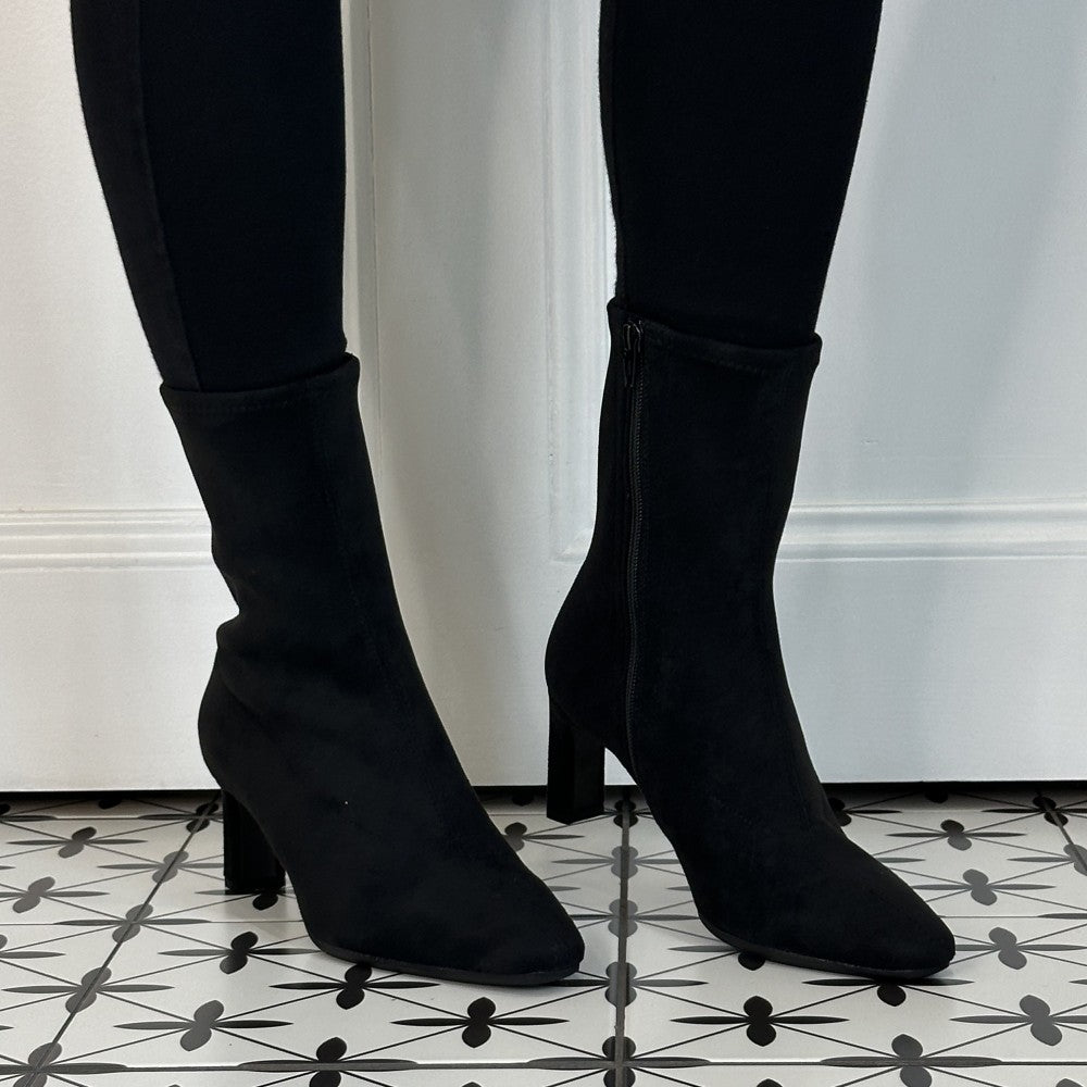 Wonders Black ankle boots with a pointed toe and block heel, worn with black leggings on a patterned black and white tile floor.