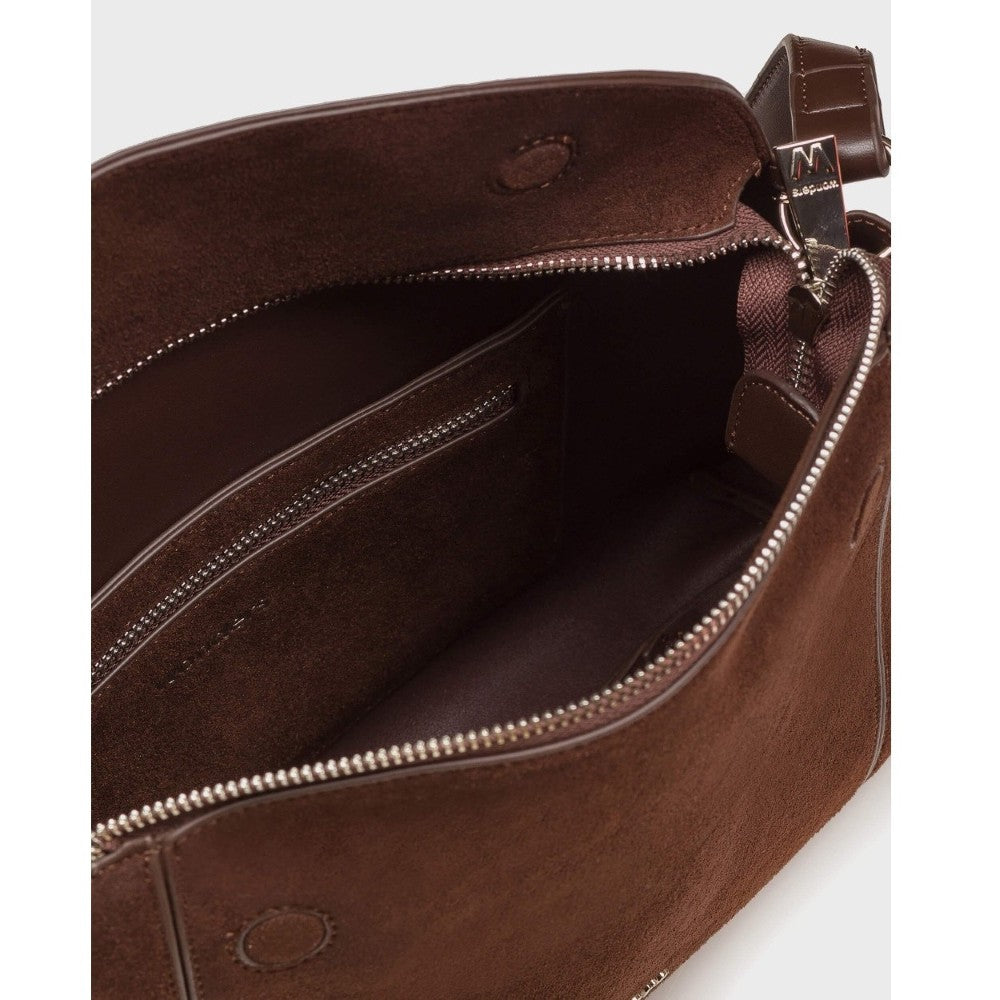 Close-up of a brown leather or faux-leather handbag interior showing the spacious compartment with silver-tone zippers and a matching brown interior lining.