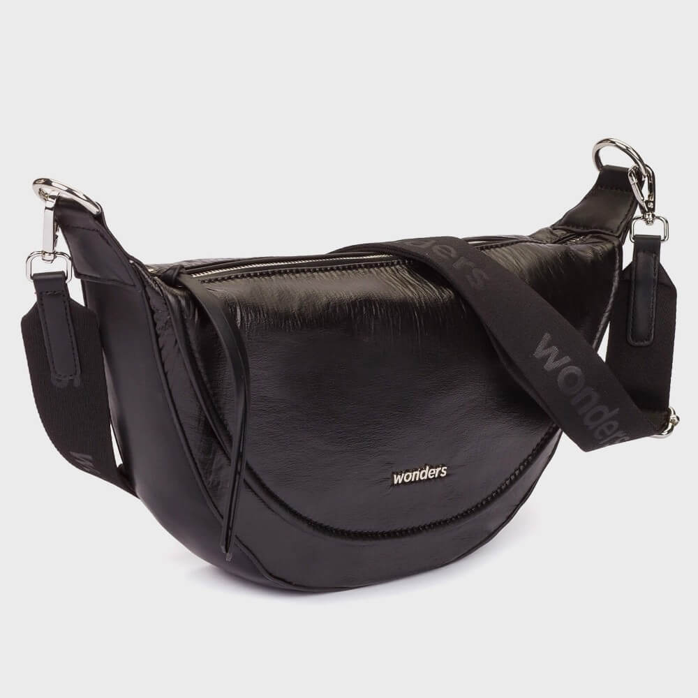 A Wonders black fabric crescent-shaped shoulder bag with a long adjustable strap and silver hardware, featuring the 'wonders' brand name in white on the front, set against a light grey background.