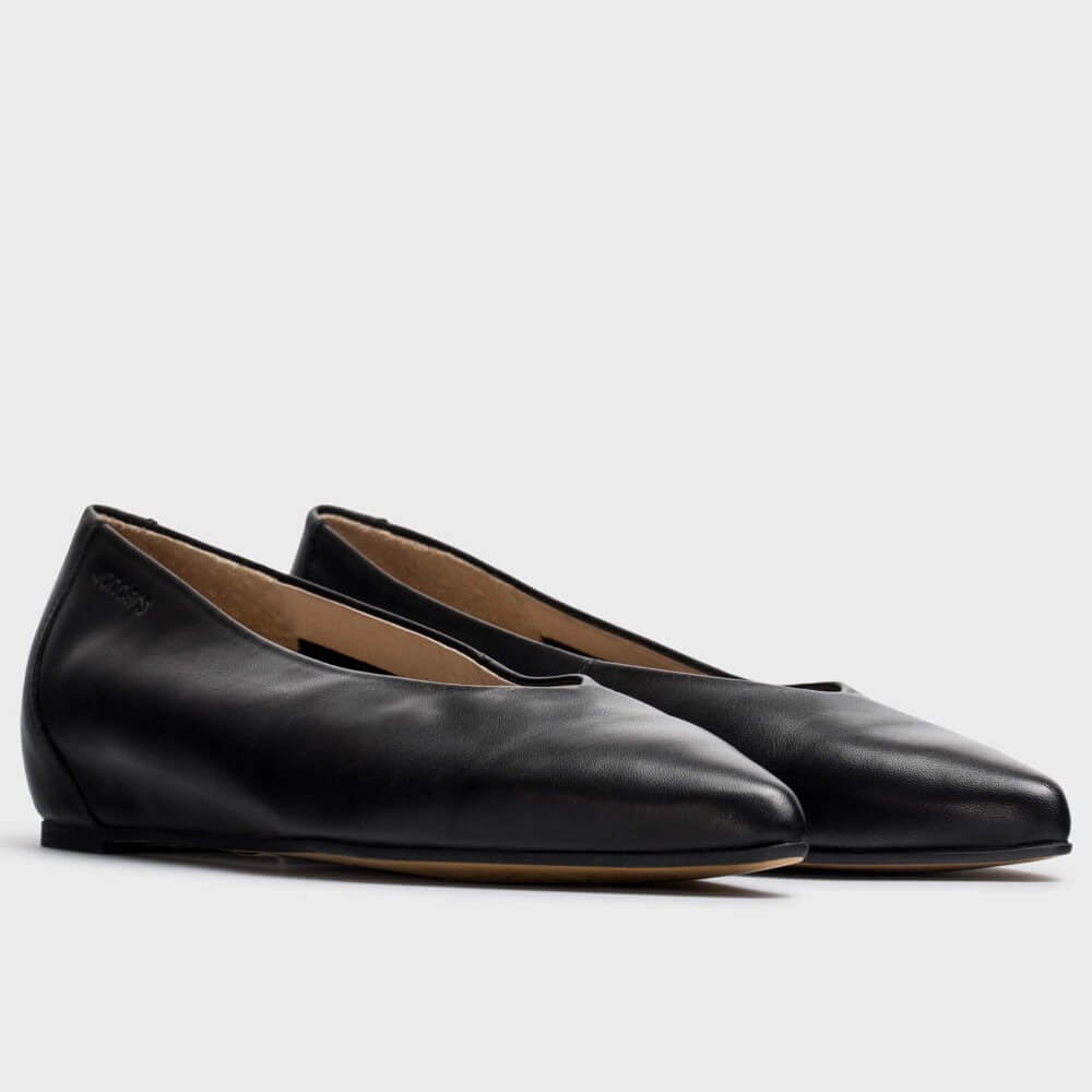 A pair of Wonders black leather ballet flats with pointed toes, shown from a three-quarters angle on a light grey background.