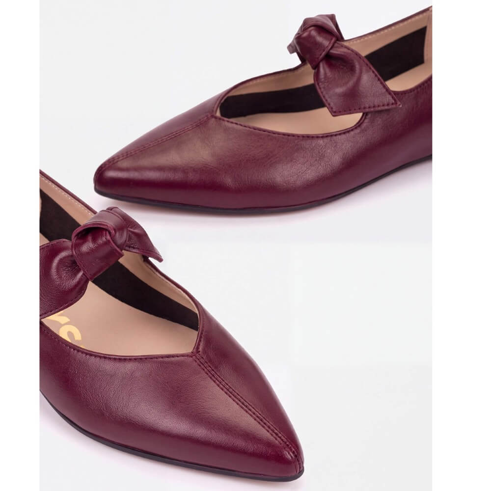 A pair of women's Wonders pointed-toe flats in burgundy faux leather, featuring a decorative bow detail across the instep, shown on a clean white background.