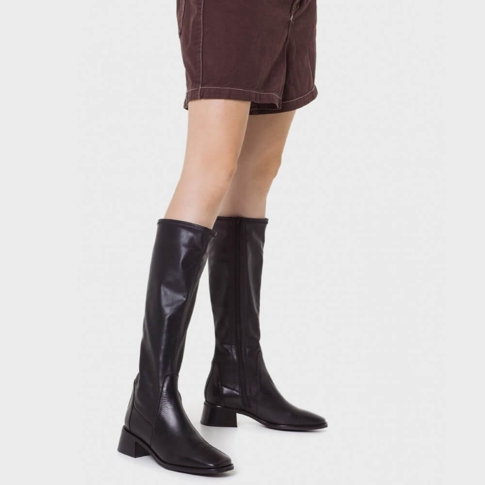 Black knee-high boots worn with brown shorts on a white background Wonders Ayla 03 Leather Knee High Boot D-1603-BLACK