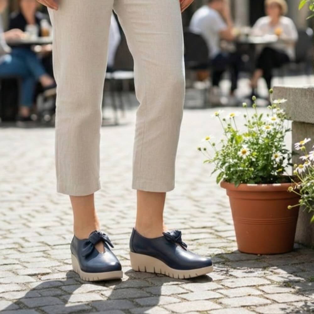 Wonders C-33159 Person wearing navy blue shoes with beige pants on a stone pavement.
