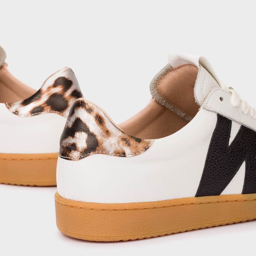 White sneakers with brown soles and leopard print heel cups on a white background