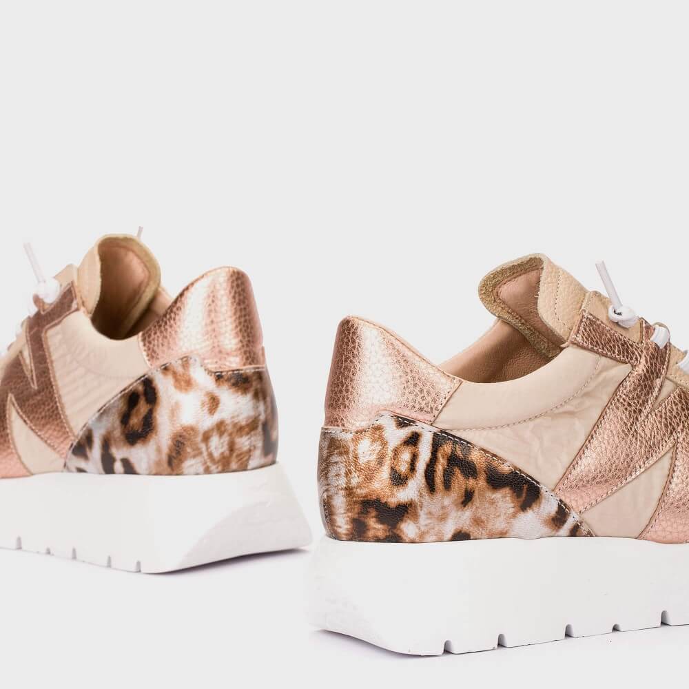 Pair of sneakers with leopard print pattern on a light background