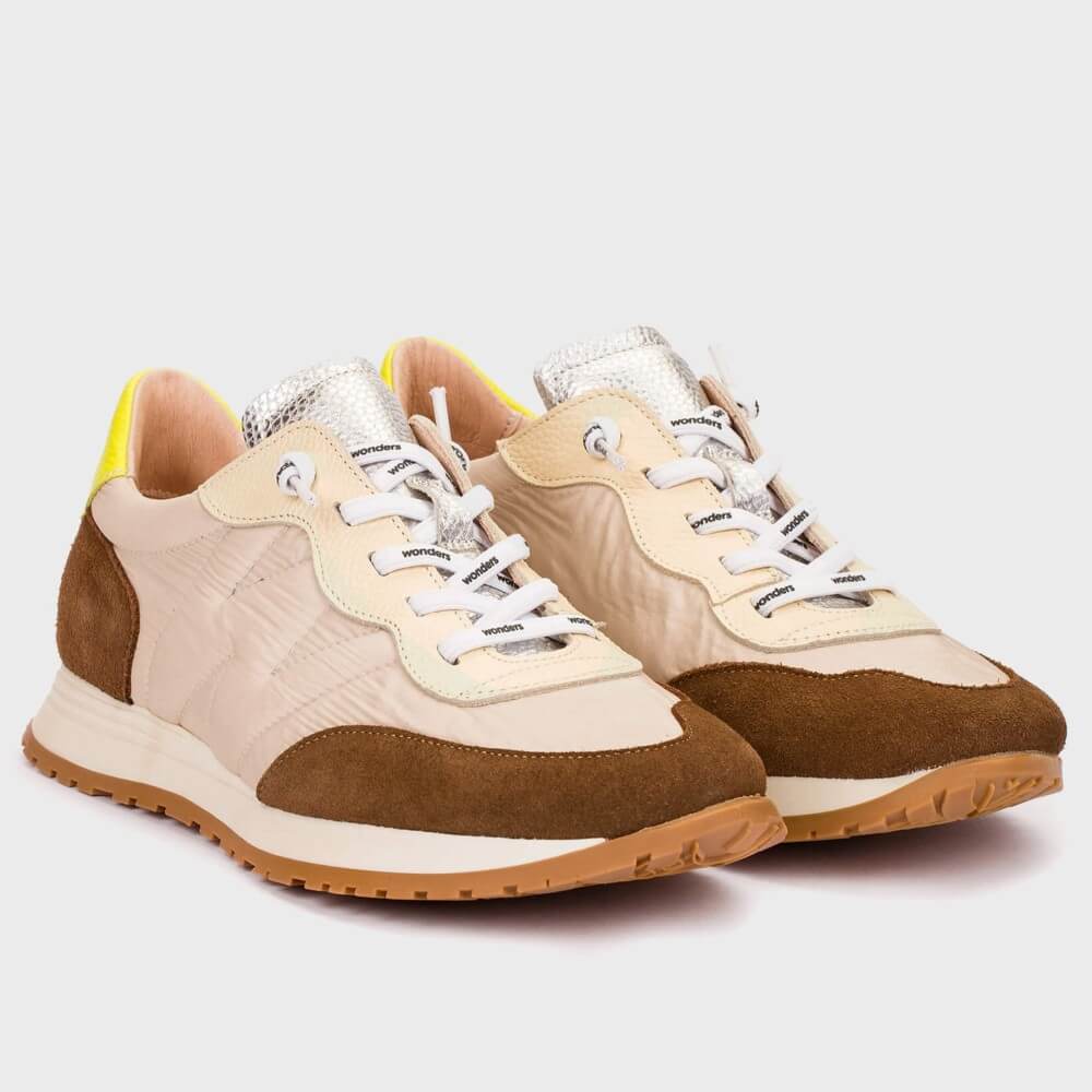 Pair of beige and brown sneakers on a light gray background