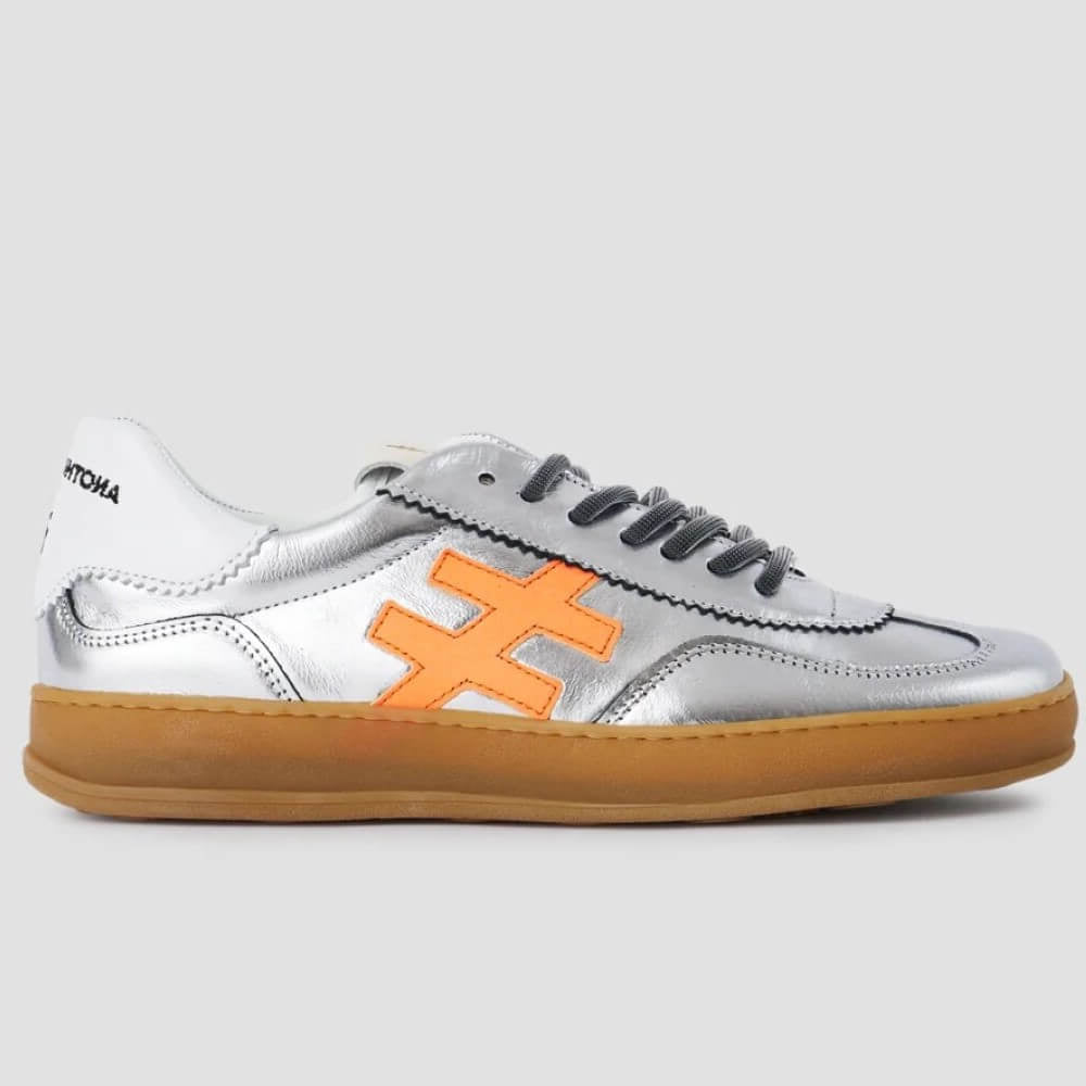 Silver Leather Sneaker with orange cross design on a grey background