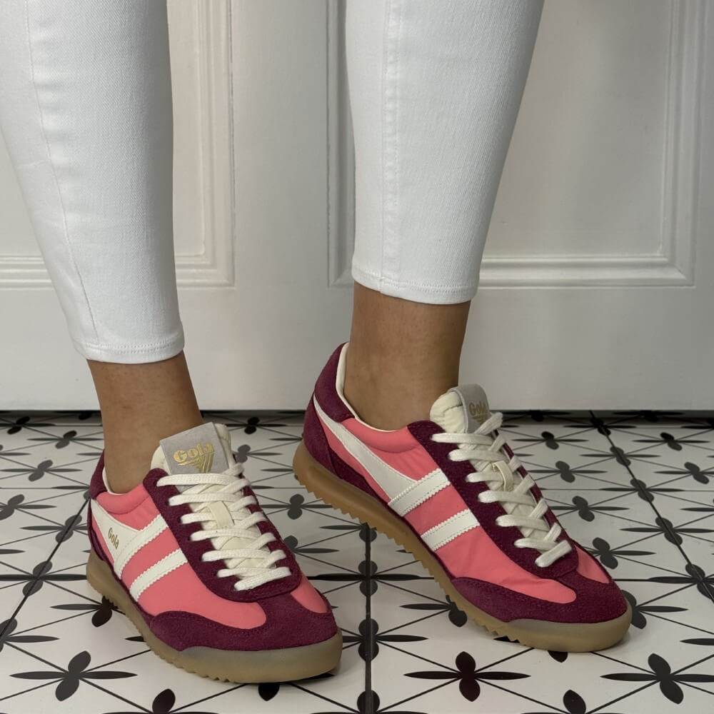 Gola Firefly Pink and maroon sneakers with white stripes worn indoors on a patterned floor