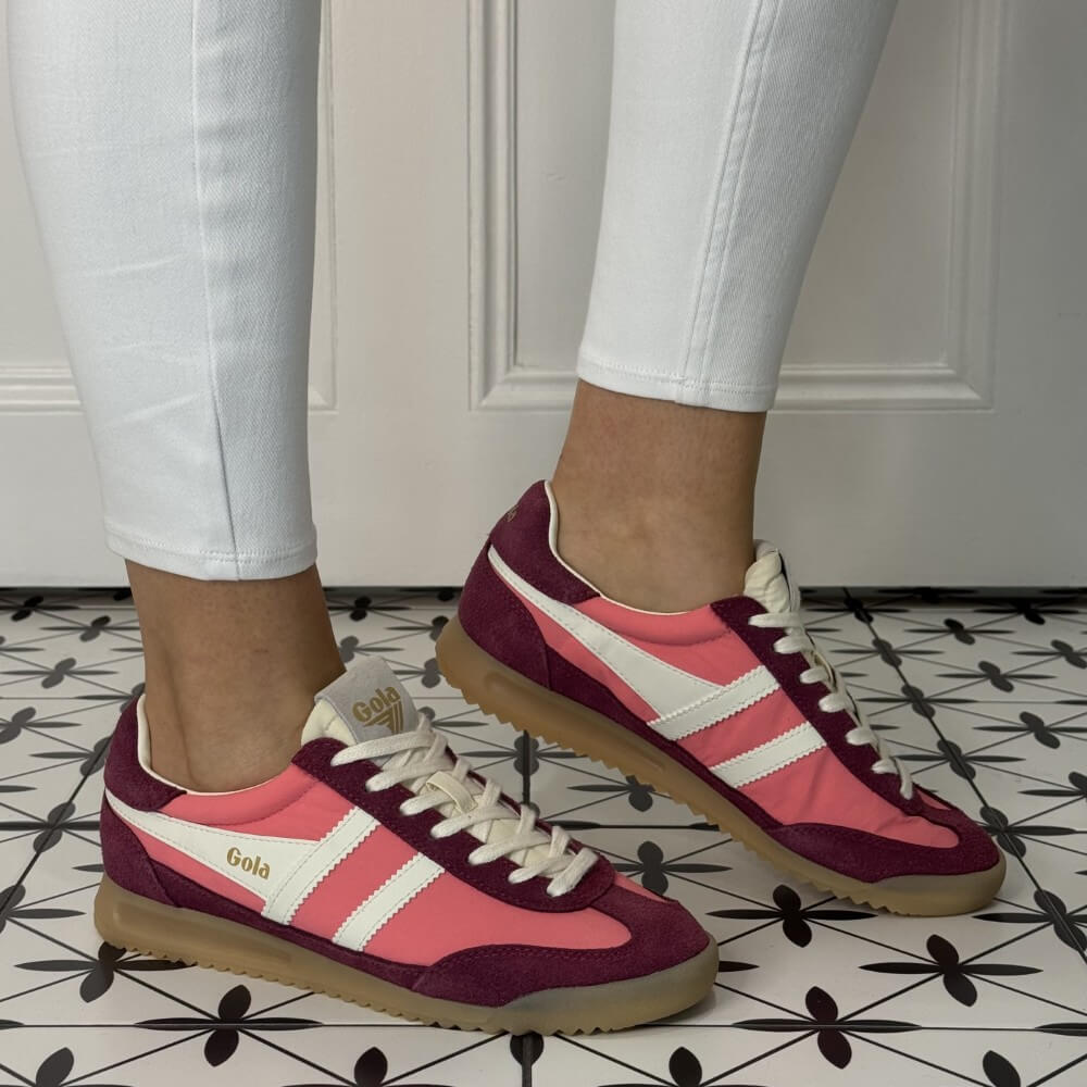 Gola Firefly Pink and maroon sneakers with white stripes worn indoors on a patterned floor