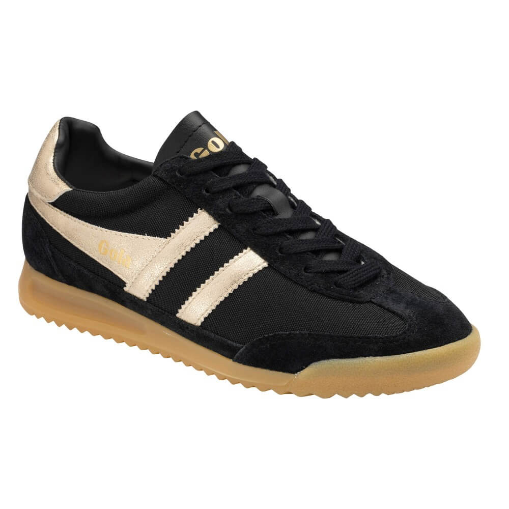 A Gola low-top sneaker in black canvas and suede with cream suede side stripes, a gold 'Gola' logo on the tongue and side, and a translucent gum sole.