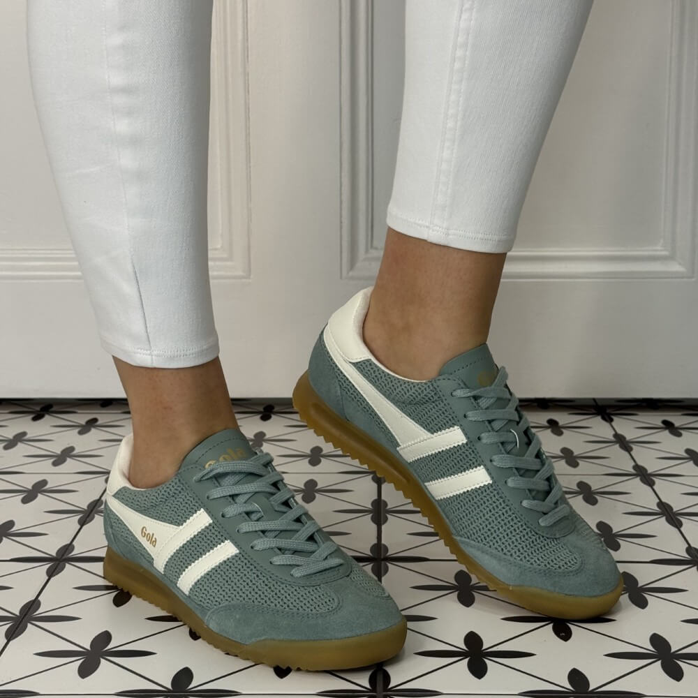 Gola Tornado Zephyr Green sneakers with white stripes worn indoors on a patterned floor.