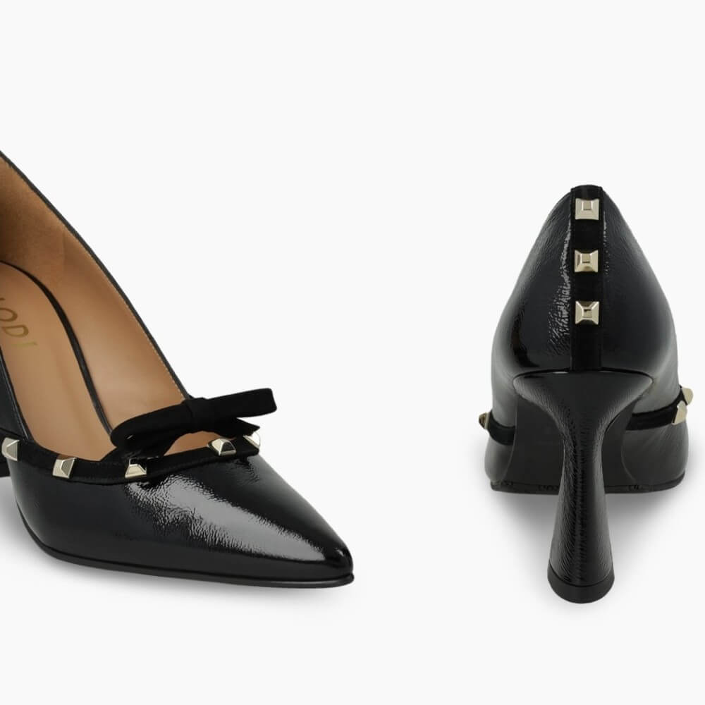 Black high-heeled shoe with decorative bow and studs on a white background Lodi RERIS pumps in black patent leather