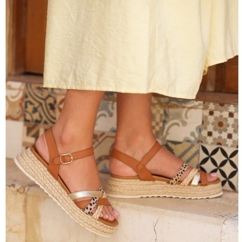 lunar flick Brown sandals with espadrille sole worn by a person on a patterned floor.