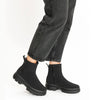 A video of a person wearing a pair of Ara Gore-Tex black ankle boots with chunky lug soles and side zippers, with black jeans