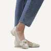 Video of person wearing a Caprice White shoe with gold buckle detail on a white background