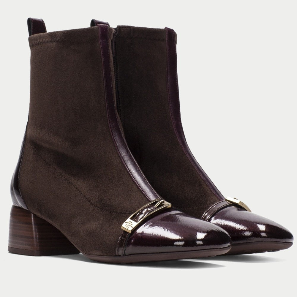 A video of a model wearing Hispanitas brown ankle boots and a grey long coat