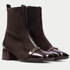 A video of a model wearing Hispanitas brown ankle boots and a grey long coat