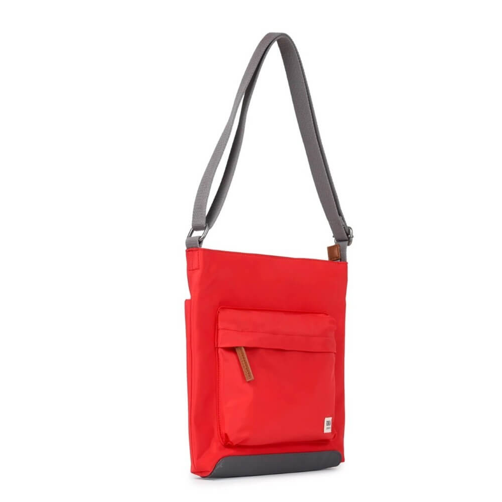 Red crossbody bag with a grey strap on a white background Roka