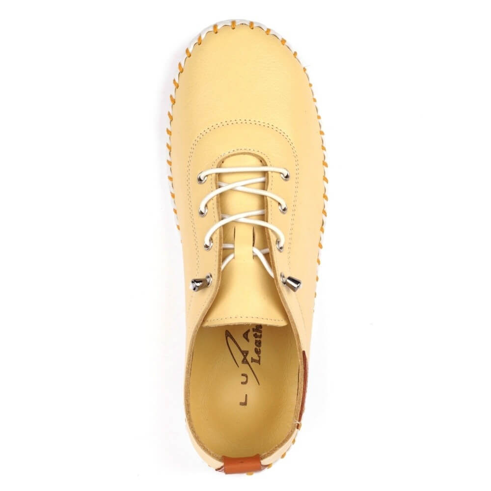 Yellow leather shoe with white laces on a white background