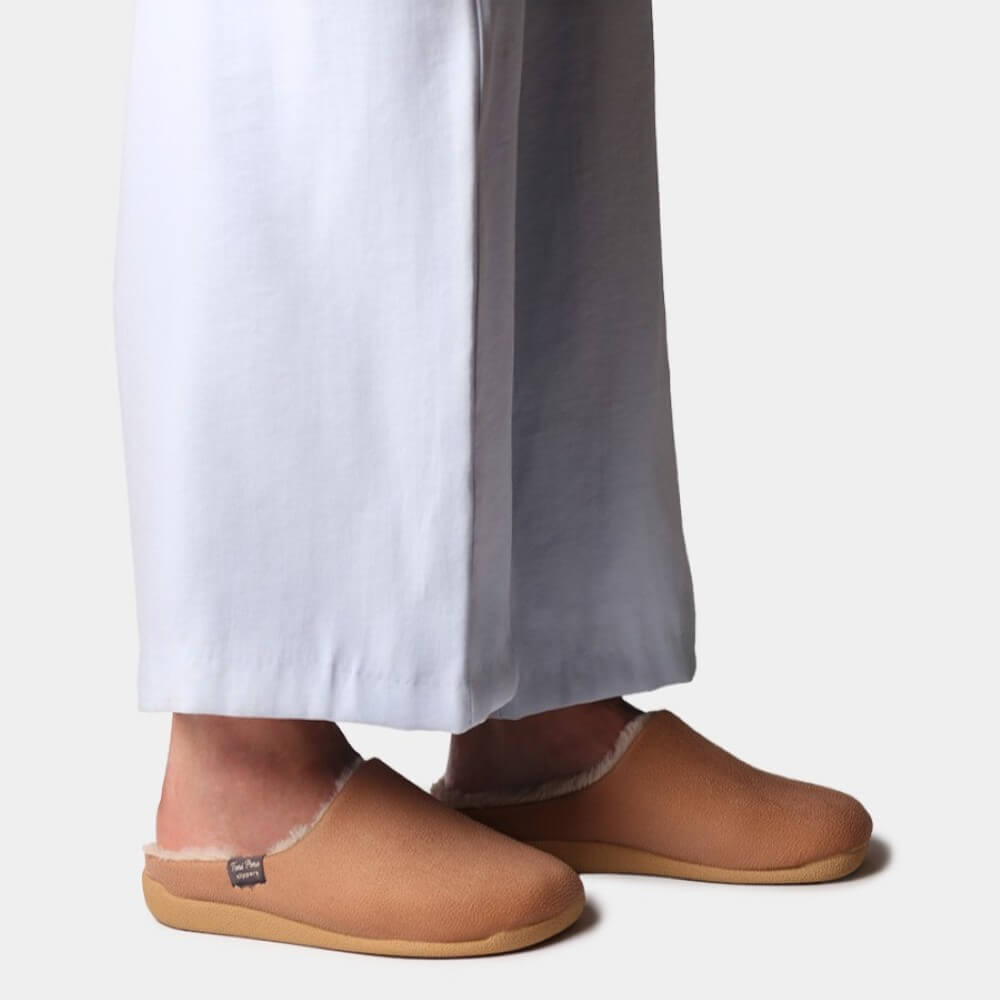 Person wearing a pair of brown slippers